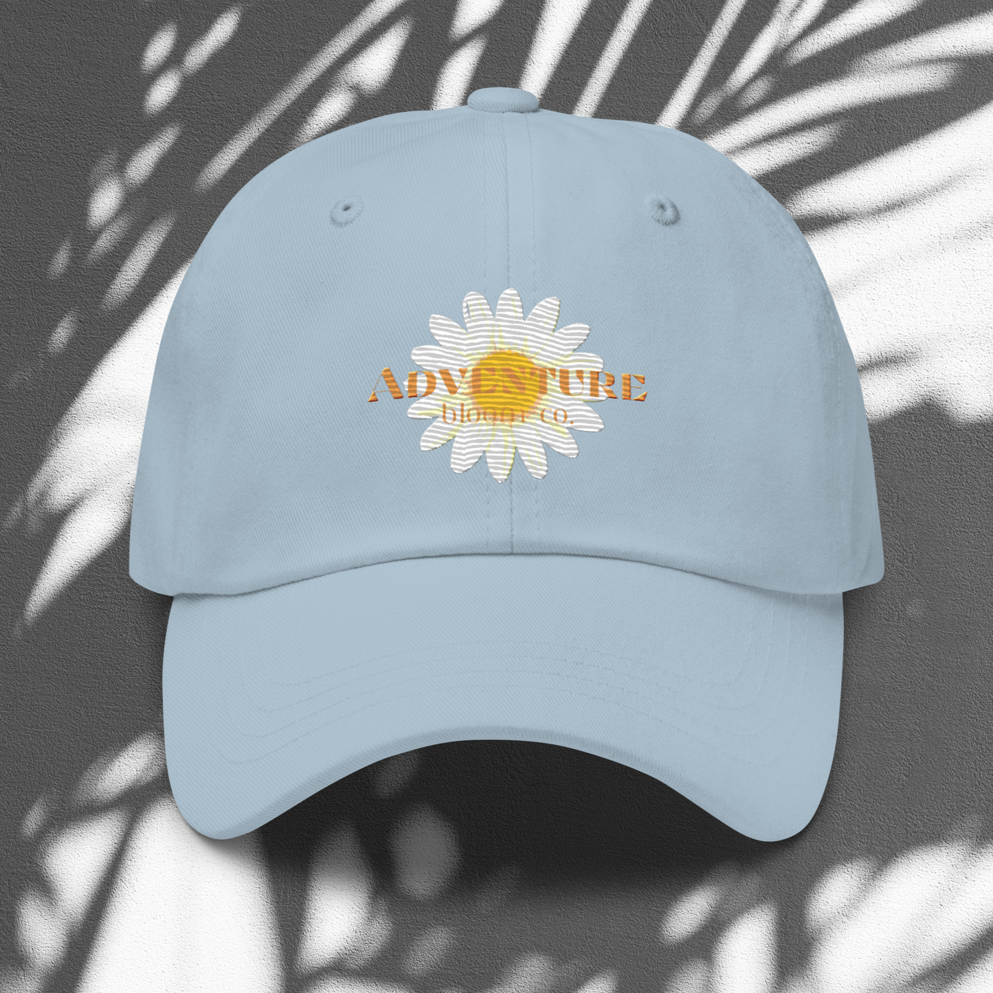 A close-up view of the Wild Bloom Baseball Cap in Light Blue by Adventure Bloom Co.